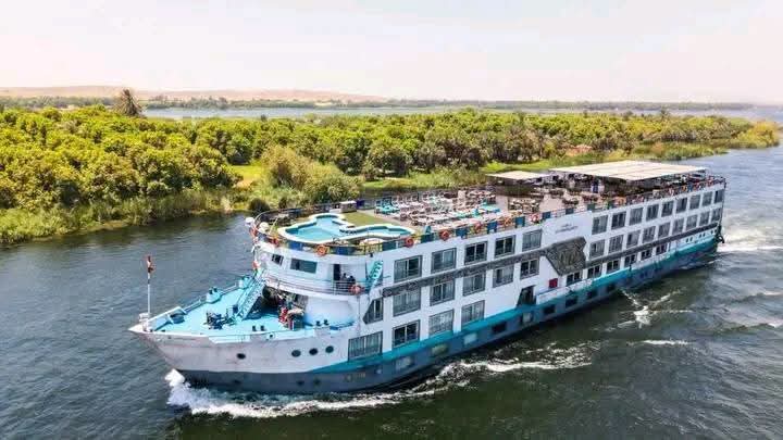 White and turquoise Nile cruise ship sailing on the river